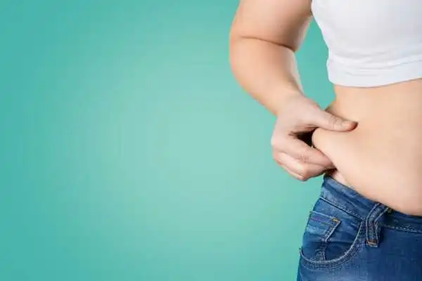 Image of woman pinching her love handles to show weight gain Burnley